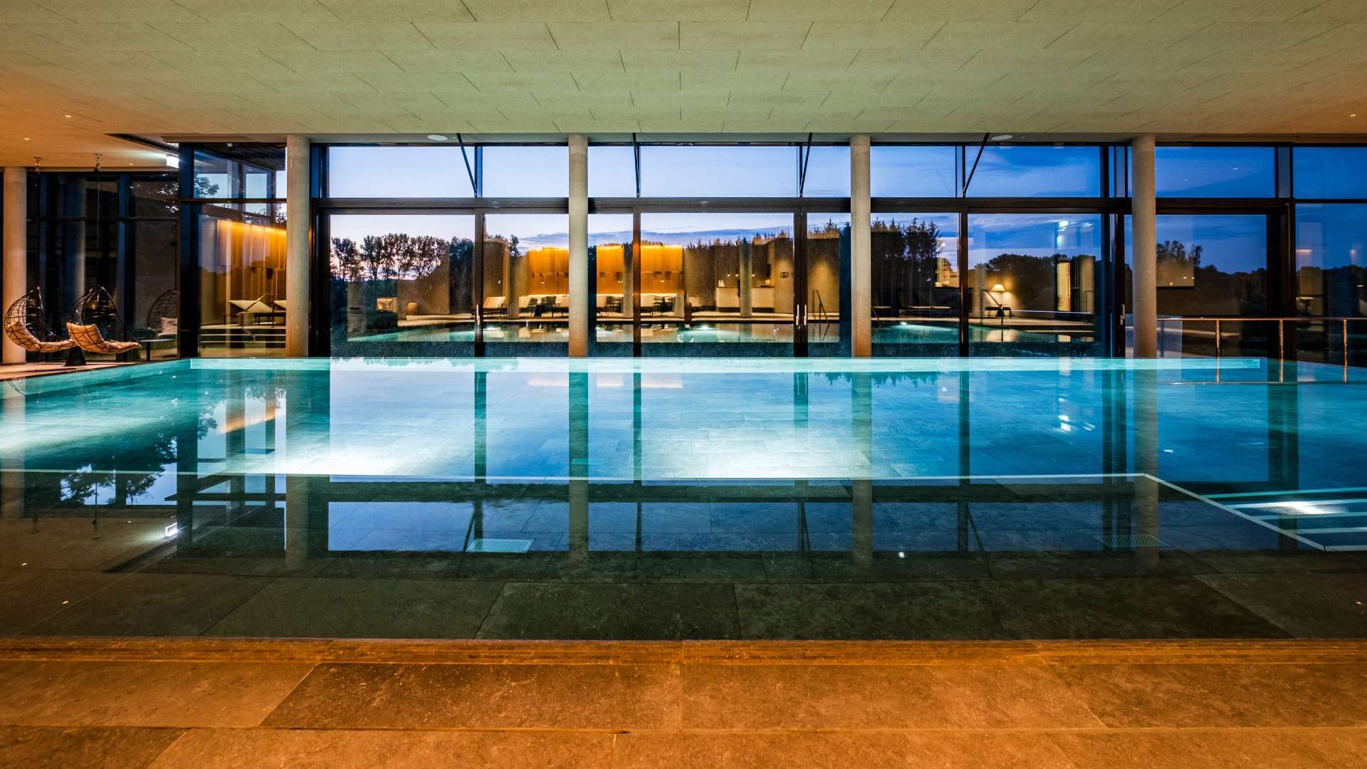 Infinity-Innenpool mit Panoramafenstern im Wellnessbereich