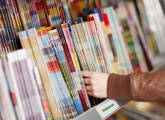 Golfzeitschriften in Deutschland 2026: Übersicht aller relevanten Golfmagazine Eine Hand greift nach einer Golfzeitschrift aus einem Stapel von Golfzeitungen